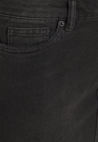 Schwarze Denim-Jeans mit Taschendetails, stabilen Nähten und einer glatten Textur. Enthält einen Metallknopf und ein klassisches Fünf-Taschen-Design.