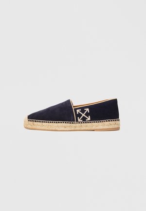 Námořnické modré semišové espadrilky s béžovou pletenou podrážkou a vyšitým bílým logem křížených šipek na boku.