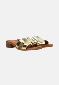 Sandalias deslizantes metálicas doradas con dos correas anchas, con detalles troquelados. Plantilla acolchada marrón y tacones bajos en bloque.