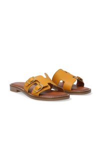 Gule læderslide sandaler med to spænde detaljer, åben tå-design og en brun polstret sål med flad sål.