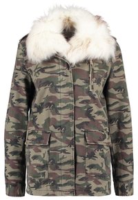 Veste camouflage verte et marron avec grand col en fausse fourrure blanche, fermeture éclair frontale, et deux poches à rabat à la taille.