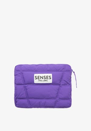 Purple padded laptop sleeve featuring a zip closure and a rectangular shape. It has a white label with "SENSES .THE LABEL" text.