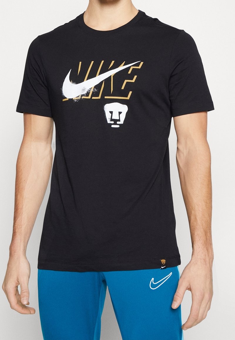 T-shirt en coton noir présentant un grand logo Nike blanc et doré ainsi qu'un graphique de lion blanc à l'avant, à manches courtes et à col rond.