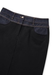 Zwarte broek met een donkerdenim tailleband en zakken. De stof is glad, met contrasterende stiksels en een sluiting met een knoop aan de voorkant.
