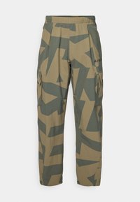 Camo cargo pants in beige and green, featuring an elastic waistband, multiple side pockets, and abstract geometric patterns.