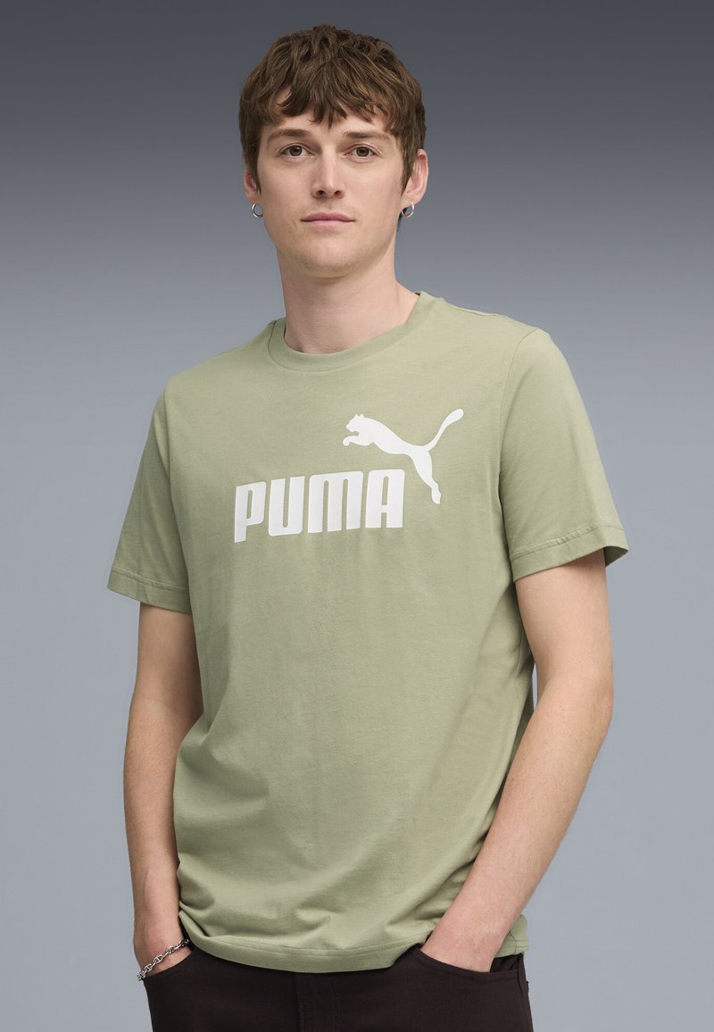 Lys grøn bomulds t-shirt med et hvidt Puma-logo og tekst. Korte ærmer, rund halsudskæring og en afslappet pasform. Minimalistisk design.