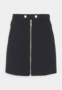 Námořnická sukně s přiléhavým střihem, zapínání na zip vpředu, dvě dekorativní zlaté knoflíky na pase a hladkou texturou.