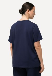 Camiseta de algodón azul marino de manga corta, con cuello redondo y un ajuste relajado; textura suave, diseño liso, sin patrones ni acentos visibles.