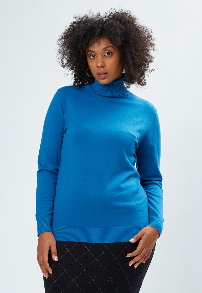 Blauer Rollkragenpullover aus weichem Material mit gerippten Bündchen und Saum. Das Design ist tailliert, mit langen Ärmeln und einer glatten Textur.