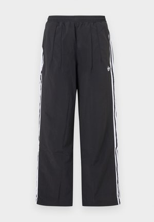 Schwarze Adidas-Trainingshose mit elastischem Bund, weißen Seitenstreifen und Adidas-Logo an der oberen linken Oberschenkel, gerader Schnitt.