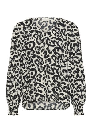 Blouse à manches longues imprimé léopard noir et blanc avec col en V et poignets froncés sur fond blanc uni.