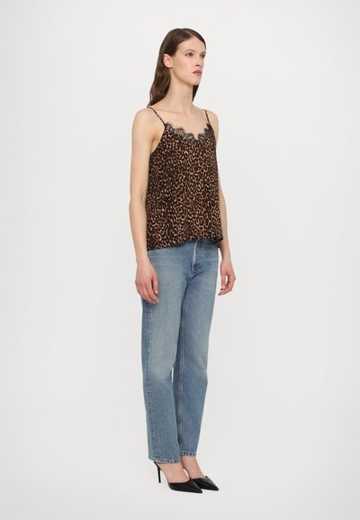 Cami-top met luipaardprint en kantafwerking, gecombineerd met lichtblauwe rechte jeans en zwarte puntige hakken. Getextureerde stof en relaxte pasvorm.