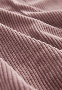 Gestructureerde stof in gedempt mauve, met prominente verticale strepen. Zachte en fluwelige afwerking, wat een gezellige uitstraling creëert.