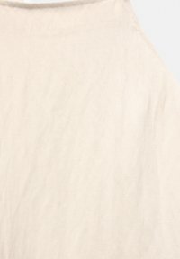 Licht beige stof met een zachte, gestructureerde oppervlakte. Beschikt over een subtiel, ongelijkmatig patroon en een ronde halslijn. De randen zijn netjes gestikt.