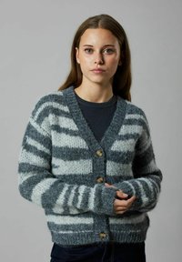 Pilkas dryžuotas kardiganas, pagamintas iš pūkuoto mezginio, su V formos iškirpte, sagčių užsegimu ir raukiniais ant rankovių su smėlio spalvos sagutėmis.