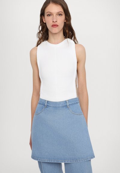 Weiße, gerippte, ärmellose Bluse kombiniert mit einem hellblauen Jeansrock mit geradem Schnitt und vorderen Taschen. Glatter Stoff und einfaches Design.