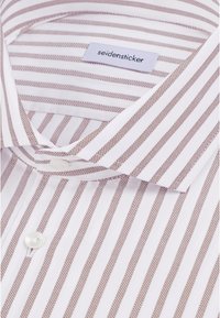Chemise blanche avec de fines bandes verticales marron et un col boutonné, avec une étiquette "seidensticker" à l’intérieur de l’encolure.