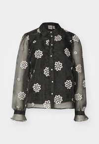 Blusa nera trasparente con ricami floreali bianchi, chiusura con bottoni e dettagli arricciati. Maniche lunghe con polsini elastici e bordi frill.