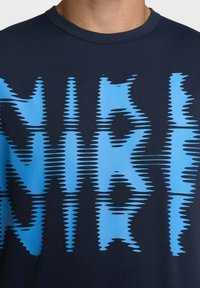 Navy blue t-shirt featuring a bold, wavy graphic pattern in bright blue. Short sleeves and a crew neckline, made of soft fabric.