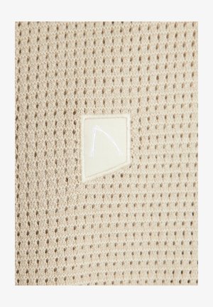 Beez värvi kohev kangas, millel on tekstureeritud, avatud silmuste muster ja ühel küljel ristkülikukujuline kangasilt, millel on valge joondis.