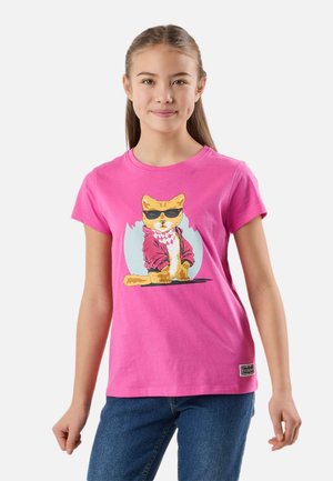 Pige iført en knaldrød T-shirt med en tegneseriekat med solbriller og en rød jakke, kombineret med blå jeans, stående mod en hvid baggrund.