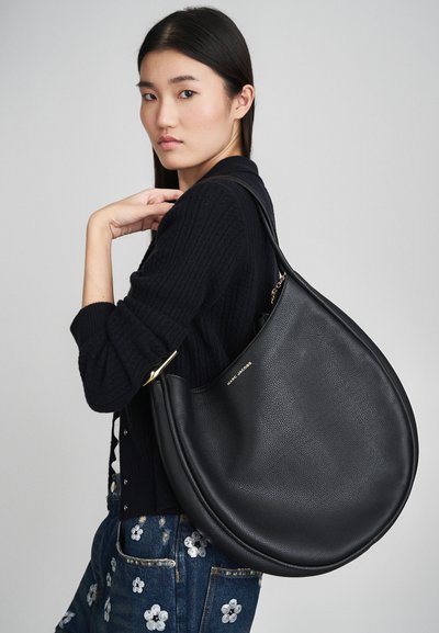 Sac hobo en cuir noir avec une forme arrondie et des accents en métal doré. Présenté avec une finition texturée, il comporte un logo sur le côté.