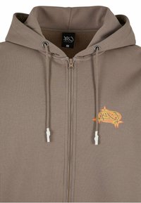 Sudadera con cremallera marrón hecha de una tela suave, que cuenta con capucha, cordones blancos y un logo gráfico naranja en el pecho.
