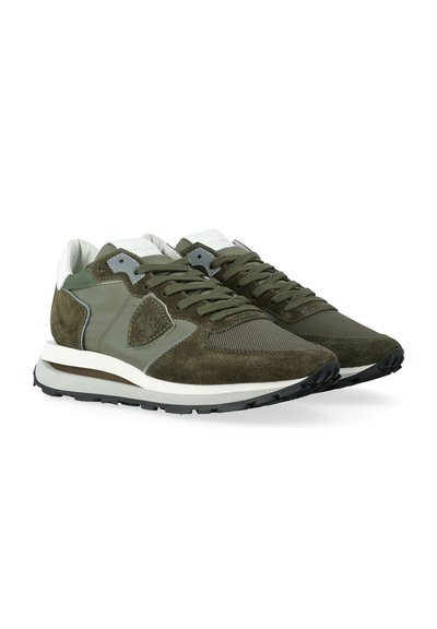 Un paio di sneakers basse olive e bianche con pannelli in suede e rete, lacci e suole in gomma nera testurizzata.