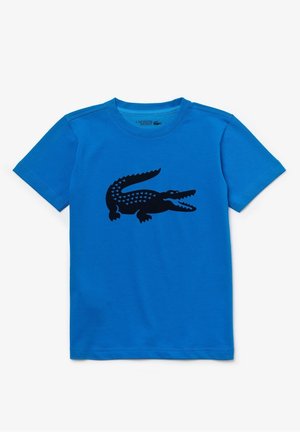 Blå T-shirt med korte ærmer med sort stiliseret krokodillegrafik på brystet, rund halsudskæring og Lacoste Sport-mærkning indeni kraven.