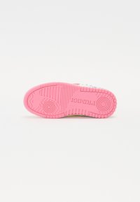 Sportsko sko med rosa gummisåle som har teksturerte gripe mønstre og en logo. Hvite detaljer og trykt design synlig på sidene.