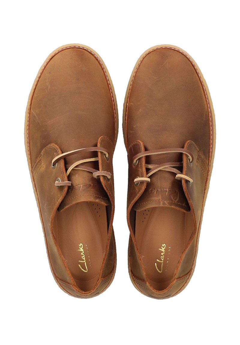 Braune Lederschuhe mit glatter Textur, Schnürdesign, runder Zehenform und leichten Stickakzenten. Das Innere verfügt über ein eingeprägtes Markenlogo.