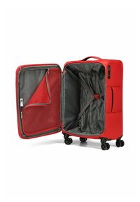 Valise rouge avec une coque dure, doublure intérieure grise, poche en mesh, sangles réglables et quatre roues noires pour la mobilité, dézippée pour montrer son contenu.