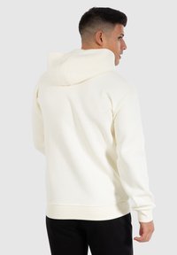 Sweatshirt blanc au toucher doux, doté d'une grande capuche, de poignets côtelés et d'un ourlet. Le design est décontracté avec une finition lisse.