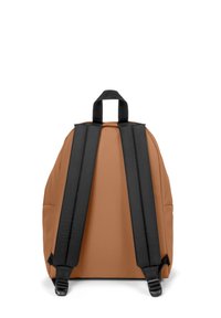 Mochila marrón con correas ajustables negras y un asa en la parte superior. Presenta una textura suave y una forma redondeada, adecuada para un uso casual.