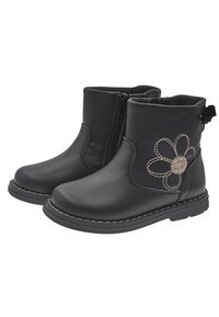Botas de cuero negro hasta el tobillo con un diseño floral en costuras color beige, cremallera lateral y suela de goma texturizada, con una lengüeta en el talón.