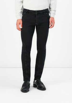 Black denim jeans with a slim fit, featuring subtle stitching and a classic five-pocket design. Worn with black leather shoes.