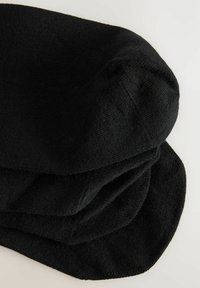 Sorte bomuldsstrømper med en glat tekstur, der har en afrundet tå og manchet, pænt stablet. Stoffet ser blødt og strækbart ud.