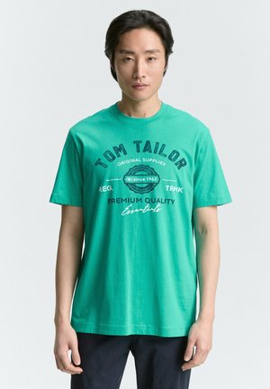 Zeleni bombažni T-shirt z okroglo izrezom, kratkimi rokavi in sprednjim tiskom z napisom "TOM TAILOR" ter podrobnostmi logotipa v kontrastnih barvah.