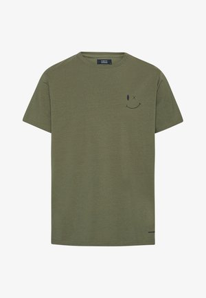 T-shirt a maniche corte verde oliva con una piccola grafica di una faccina sorridente che ammicca nera sul lato sinistro del petto e colletto rotondo.