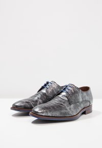 Chaussures de ville en cuir gris avec un motif texturé embossé. Présentent des lacets bleus et une semelle accentuée de bois marron. Design classique d'oxford.