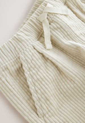 Krém színű kord rövidnadrág függőleges bordázott textúrával, állítható húzózsinóros derékrésszel és oldalzsebekkel.