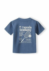T-shirt in cotone blu con maniche corte, caratterizzato da una grafica bianca raffigurante una racchetta da tennis, testo e dettagli di palme sul retro.