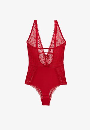 Bodysuit en dentelle rouge avec décolleté en V plongeant, dos strappé et bordure en forme de vagues. Partie inférieure lisse avec fermetures à pression au bas.