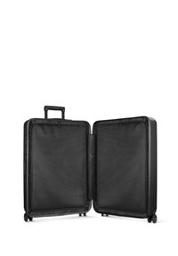 Valise noire avec un extérieur rigide, deux compartiments et une poignée rétractable. L'intérieur comprend des diviseurs en tissu maillé et des fermetures éclair.