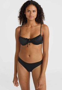 Set bikini nero composto da un bralette arricciato con spalline regolabili e dettaglio in cravatta, abbinato a slip bikini a vita bassa coordinati.