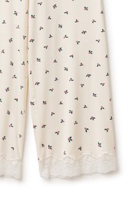 Béžové pyžamové kalhoty s malým vzorem cesmíny v zelené a červené barvě, zdobené jemnou krajkovou lemovkou na lemu a volným střihem.