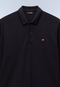 Polo de color azul marino hecho de tela texturizada, con un cuello de tres botones y una pequeña bandera noruega bordada en el pecho.