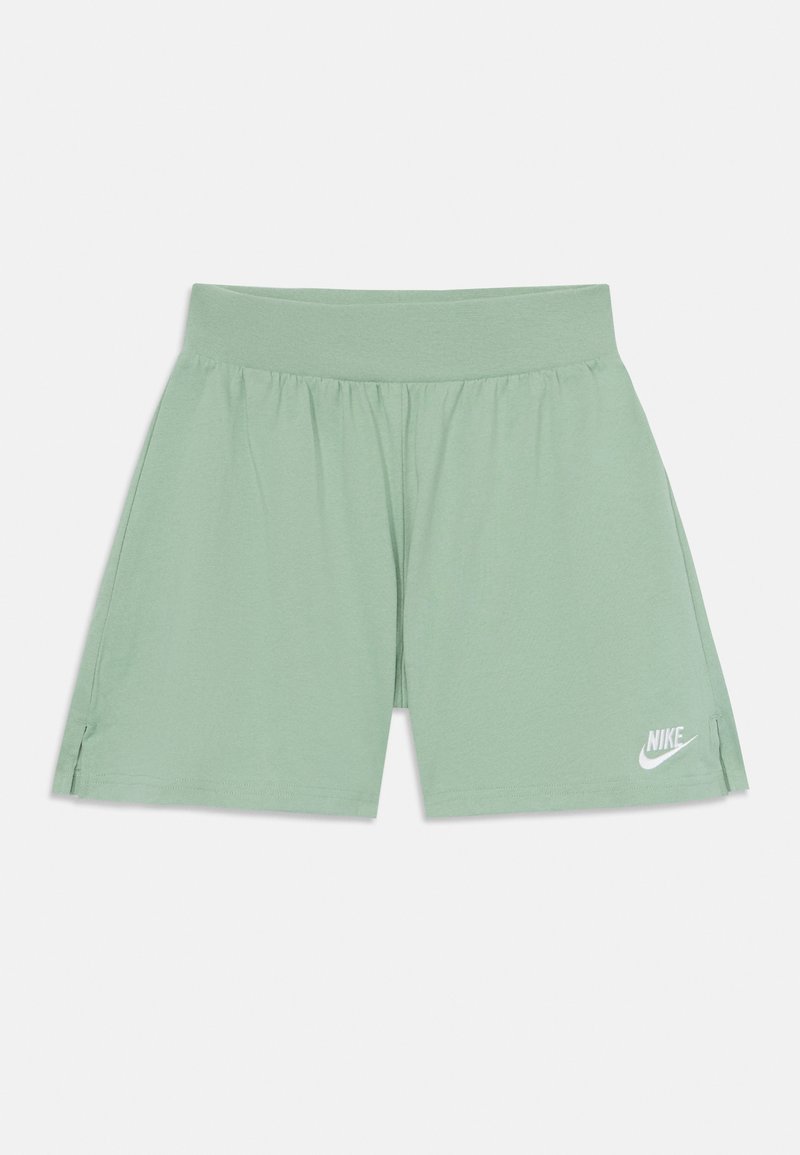 Gaiši zaļi sporta šorti ar elastīgu jostu, sānu šķeltnēm un balto Nike logo apakšējā kreisajā pusē.
