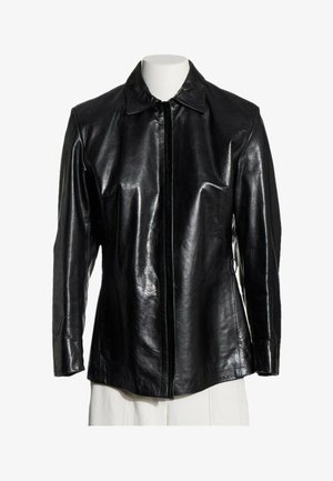 Chaqueta de cuero negra de manga larga con cuello y cremallera frontal, mostrada en un torso de maniquí blanco sobre un fondo blanco.