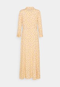 Longue robe jaune à manches longues et petit col, recouverte d'un motif floral violet clair, vue de dos.